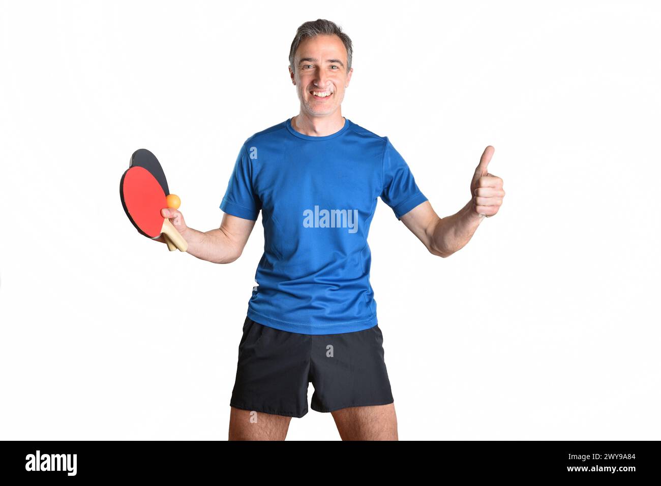 Smiling man in sportswear with rackets and ping pong ball with hand making ok sign and white isolated background Stock Photo