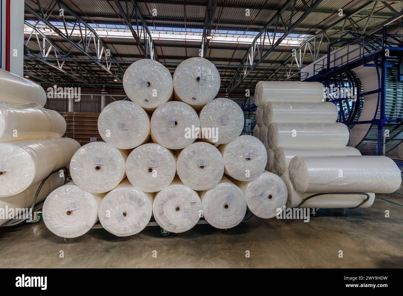Packs of rolled foam rubber in warehouse. Stock Photo