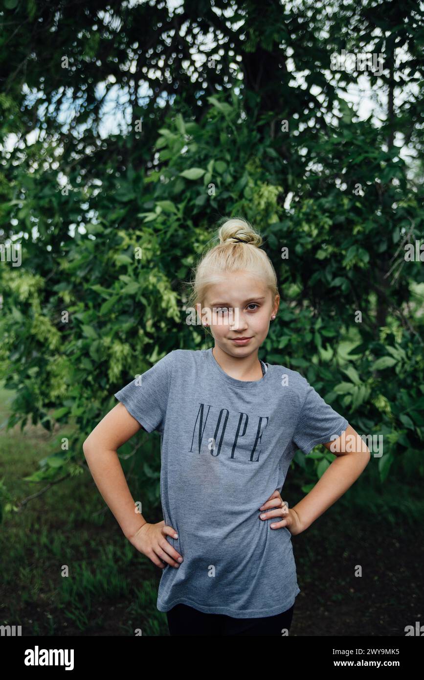 Preteen girl with attitude stands with hands on her hips outdoors Stock ...