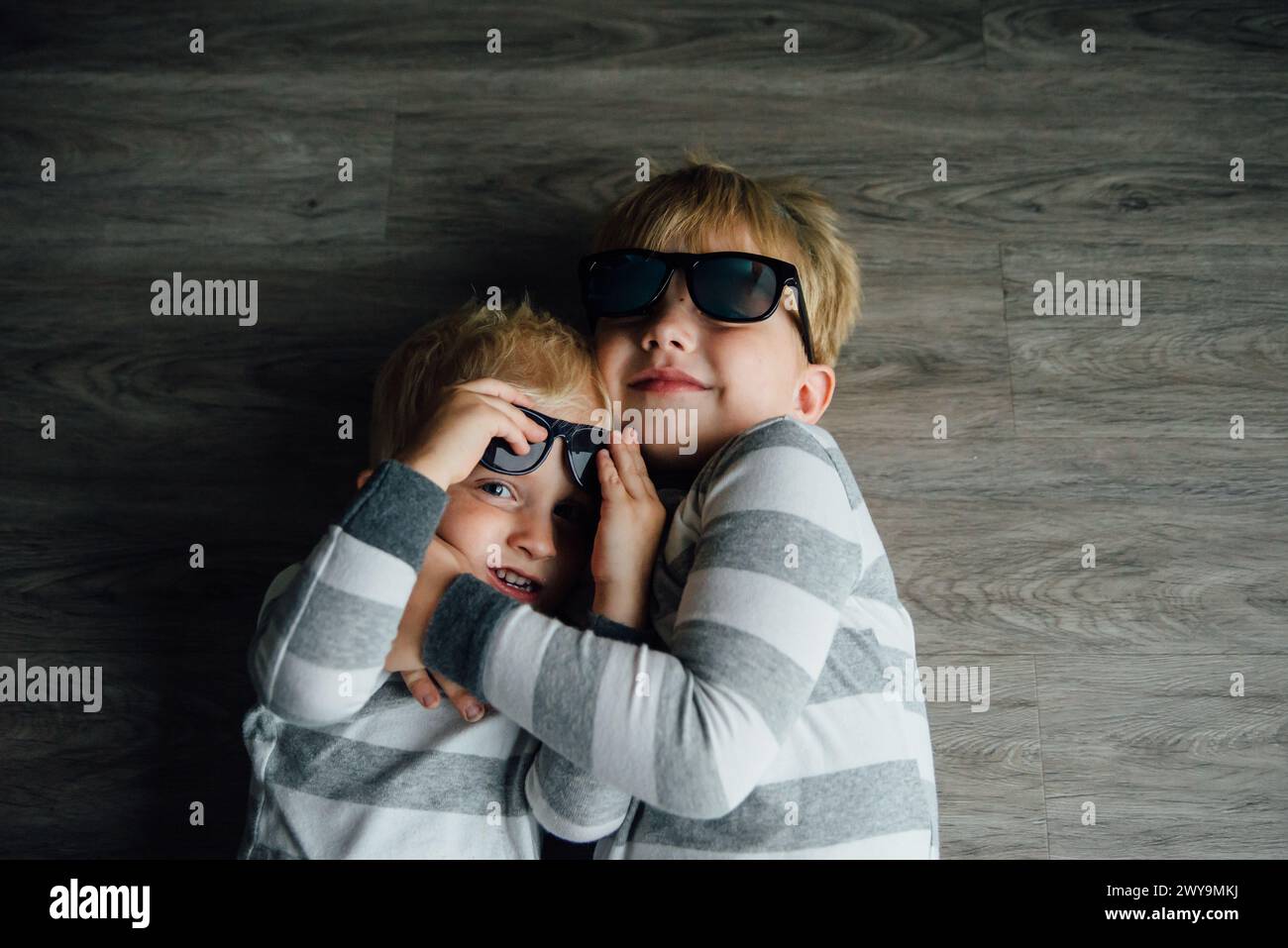 Portrait of silly brothers wearing sunglasses and hugging Stock Photo