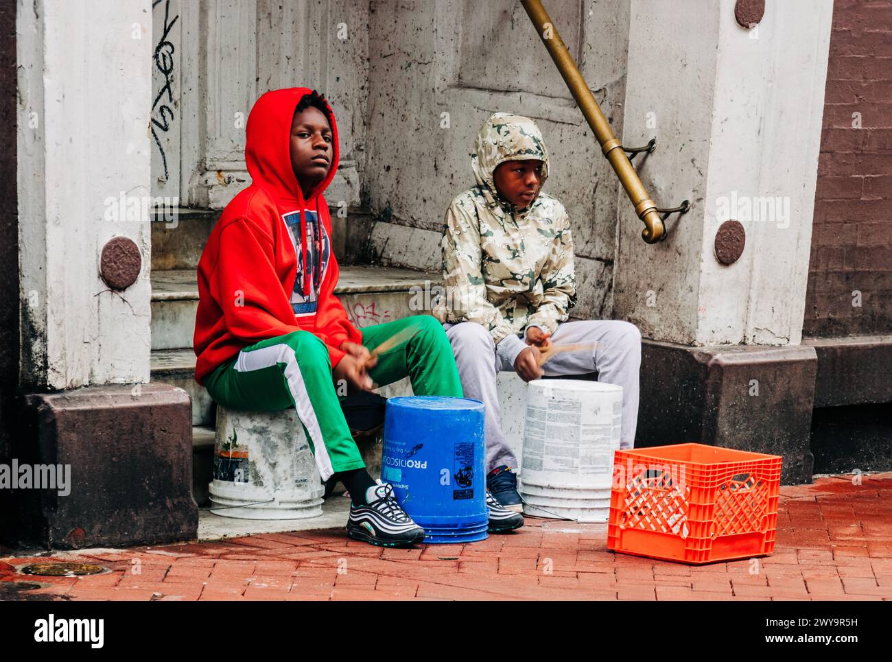 Two African American boys drumming on buckets in French Quarter Stock Photo