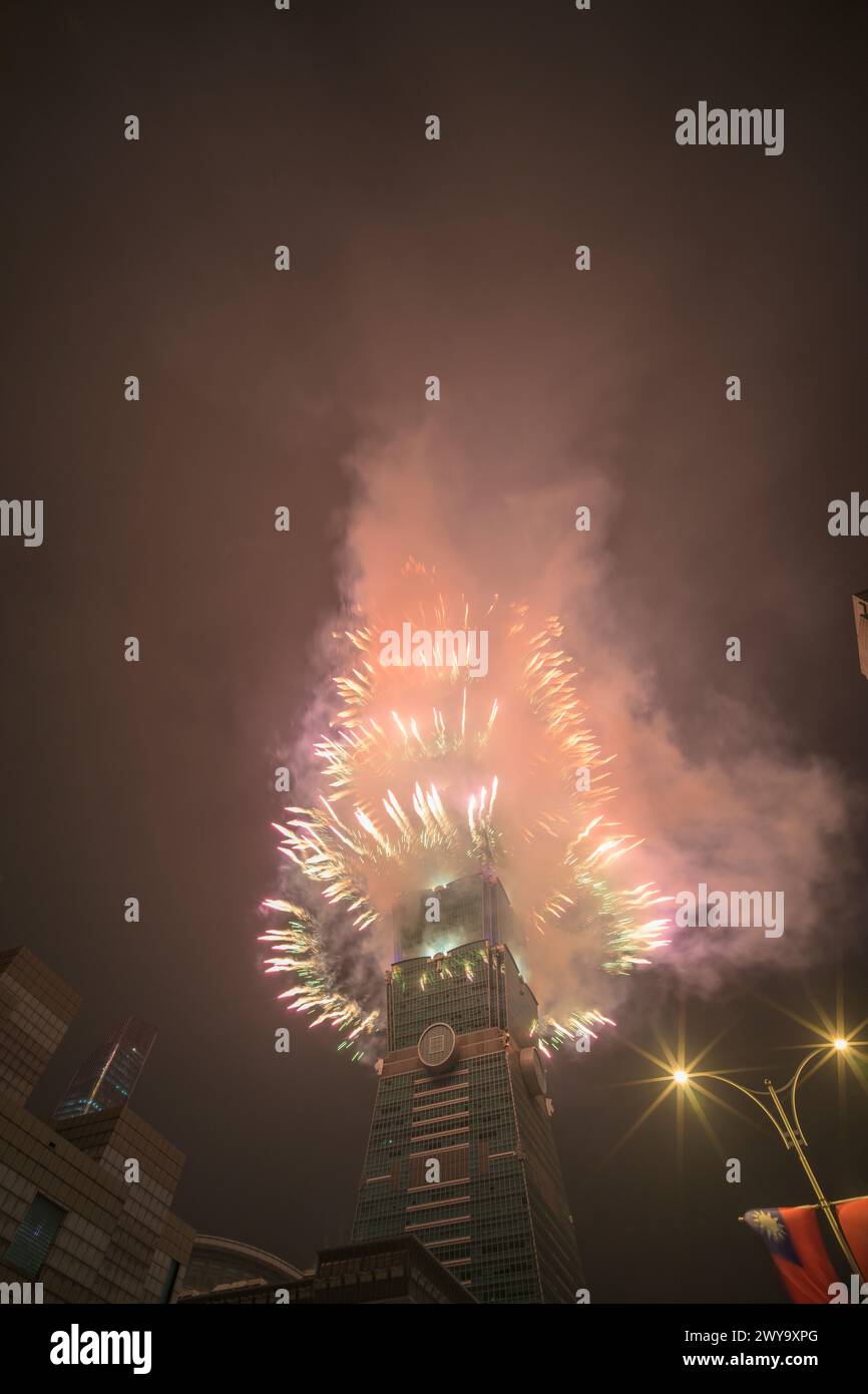 The sky is lit up with a spectacular display of fireworks from Taipei 101 tower Stock Photo