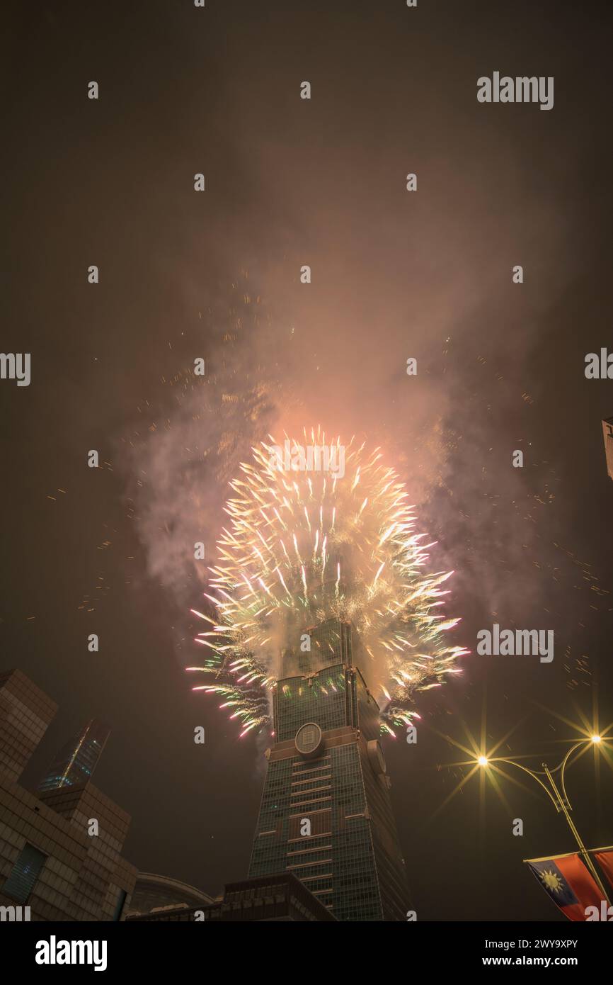 The sky is lit up with a spectacular display of fireworks from Taipei 101 tower Stock Photo