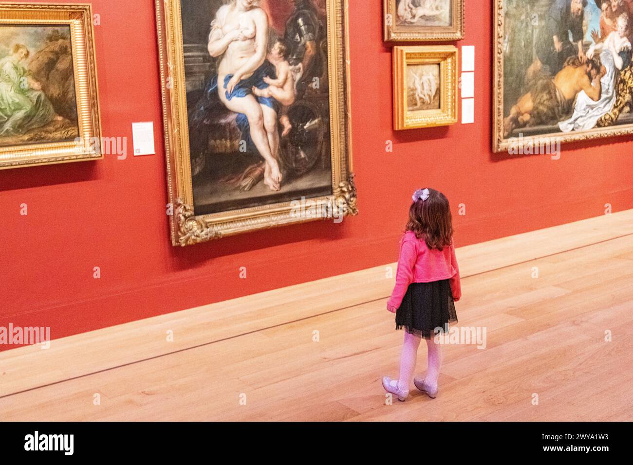 A young girl looking at a painting during a wedding at Dulwich Picture Gallery in London, UK Stock Photo