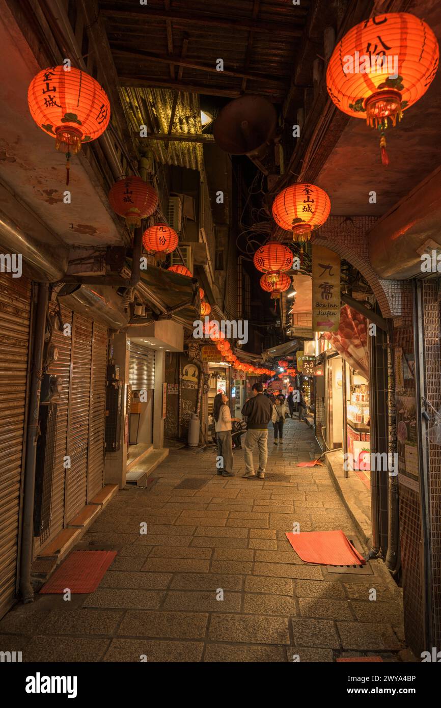 Jiufen night market lit by red lanterns with shops and people Stock Photo