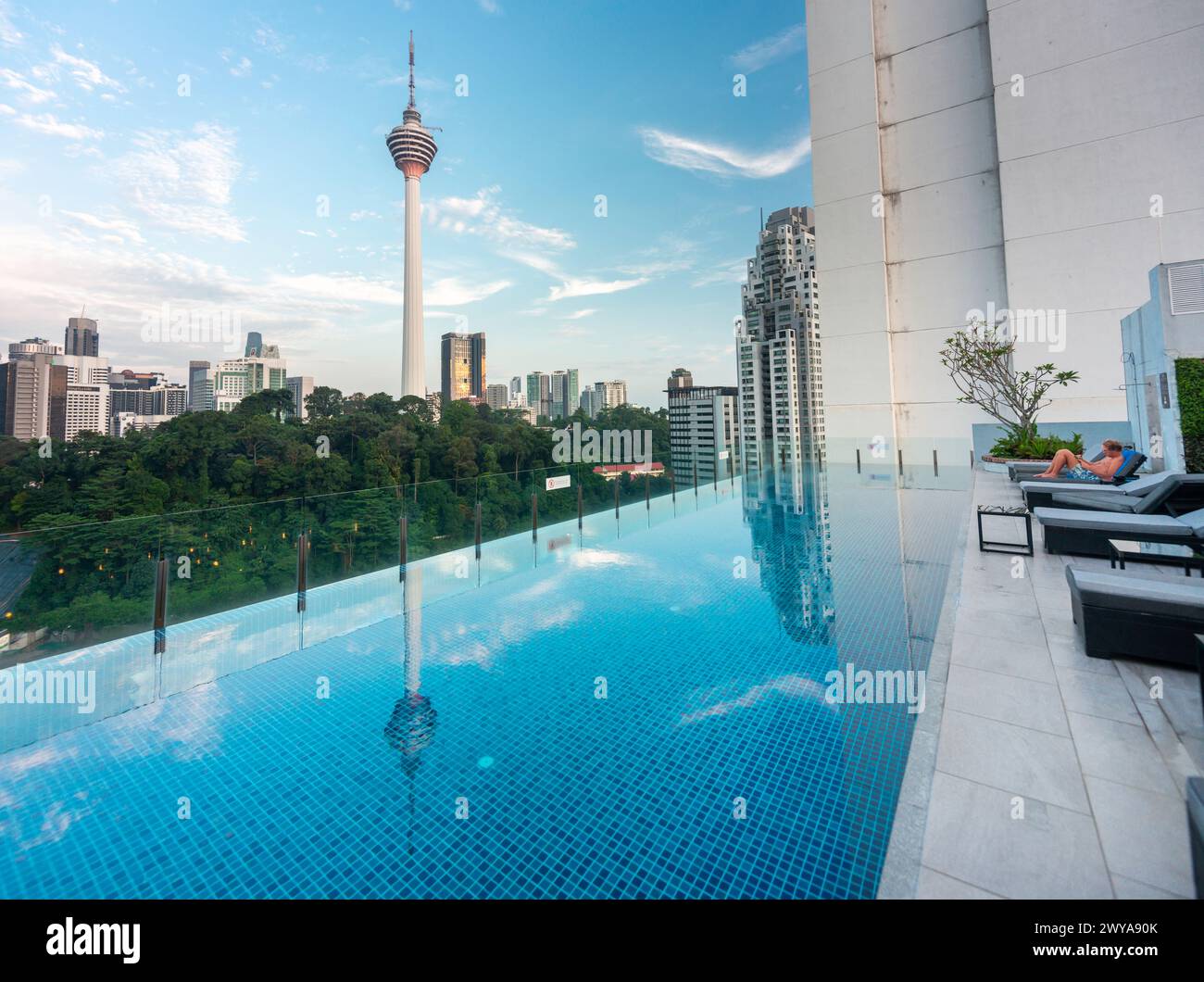 Kuala Lumpur,Malaysia-April 20 2023: The hotel swimming pool and bar area,offering views across the modern city skyline and KL Tower. Stock Photo