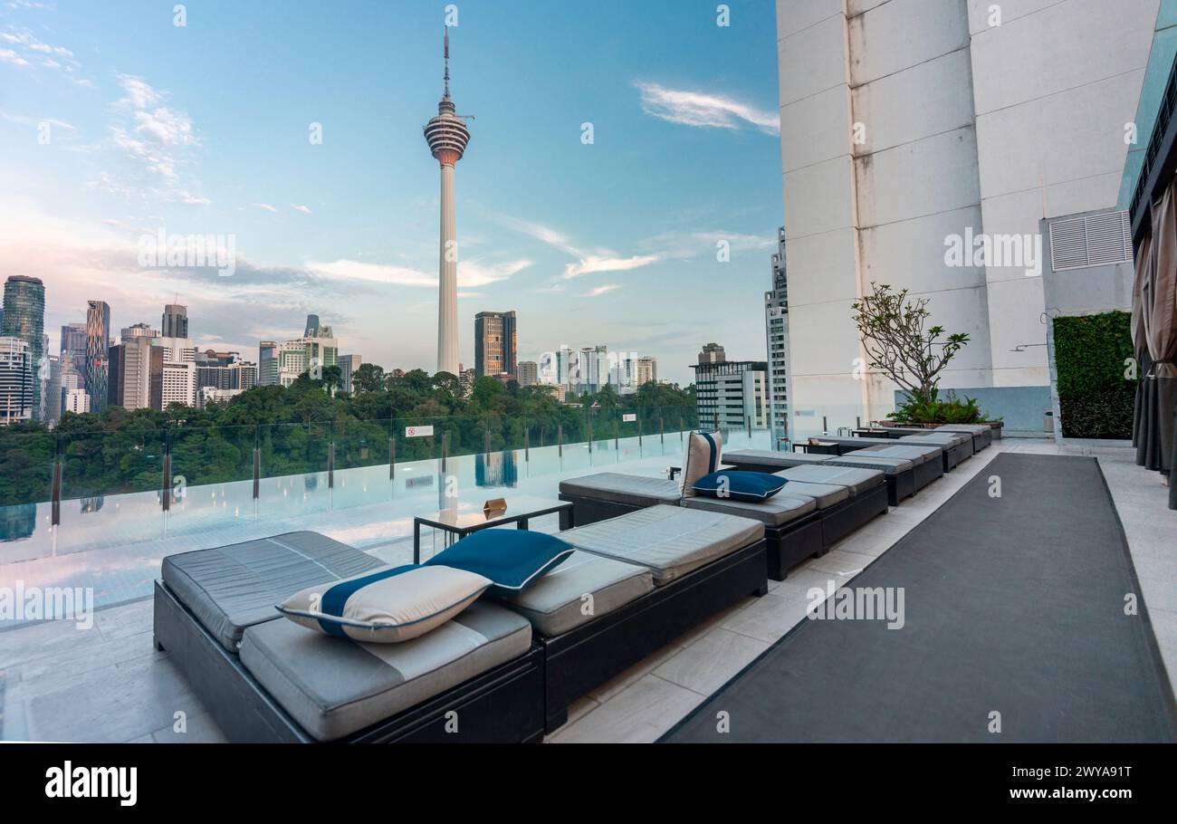 Kuala Lumpur,Malaysia-April 20 2023: The hotel swimming pool and bar area,offering views across the modern city skyline and KL Tower. Stock Photo