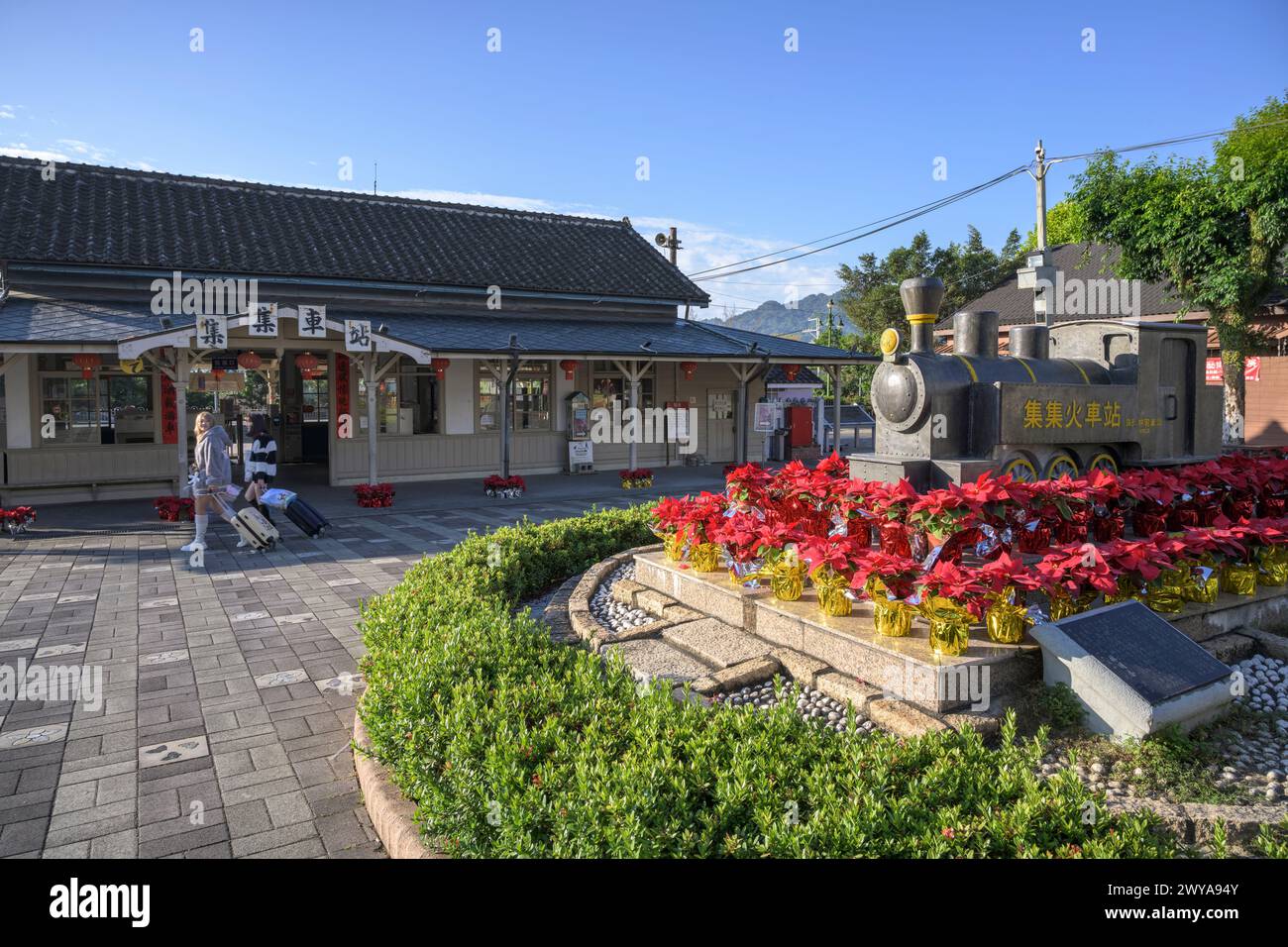 Girls walking with luggage in front of Jiji railway station Stock Photo