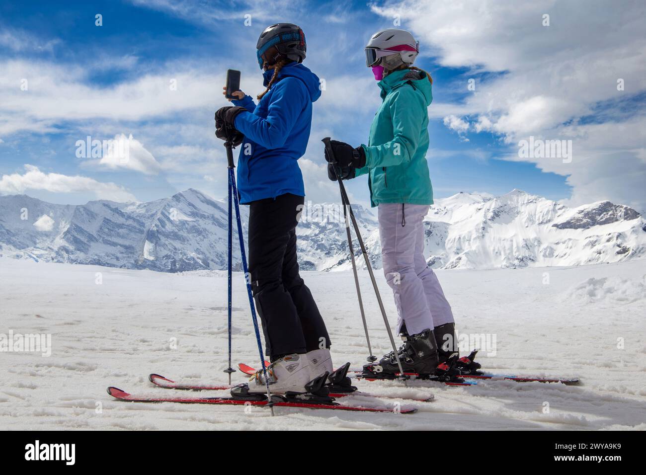 Two female skiers in front of the panorama of the Bernese Alps in Grindelwald, Switzerland Stock Photo
