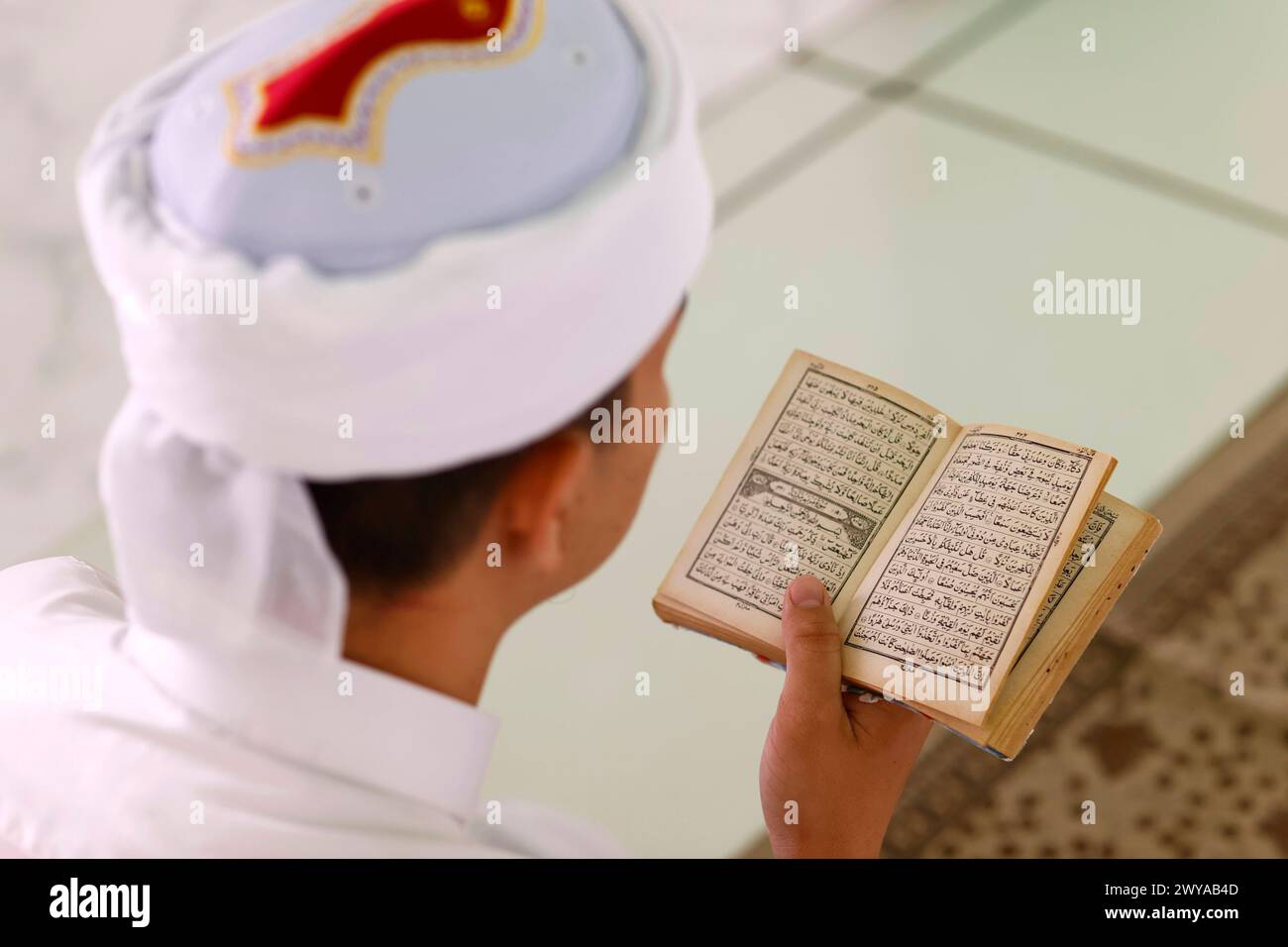 Muslim man reading an Arabic Holy Quran Koran, Jamiul Azhar Mosque ...