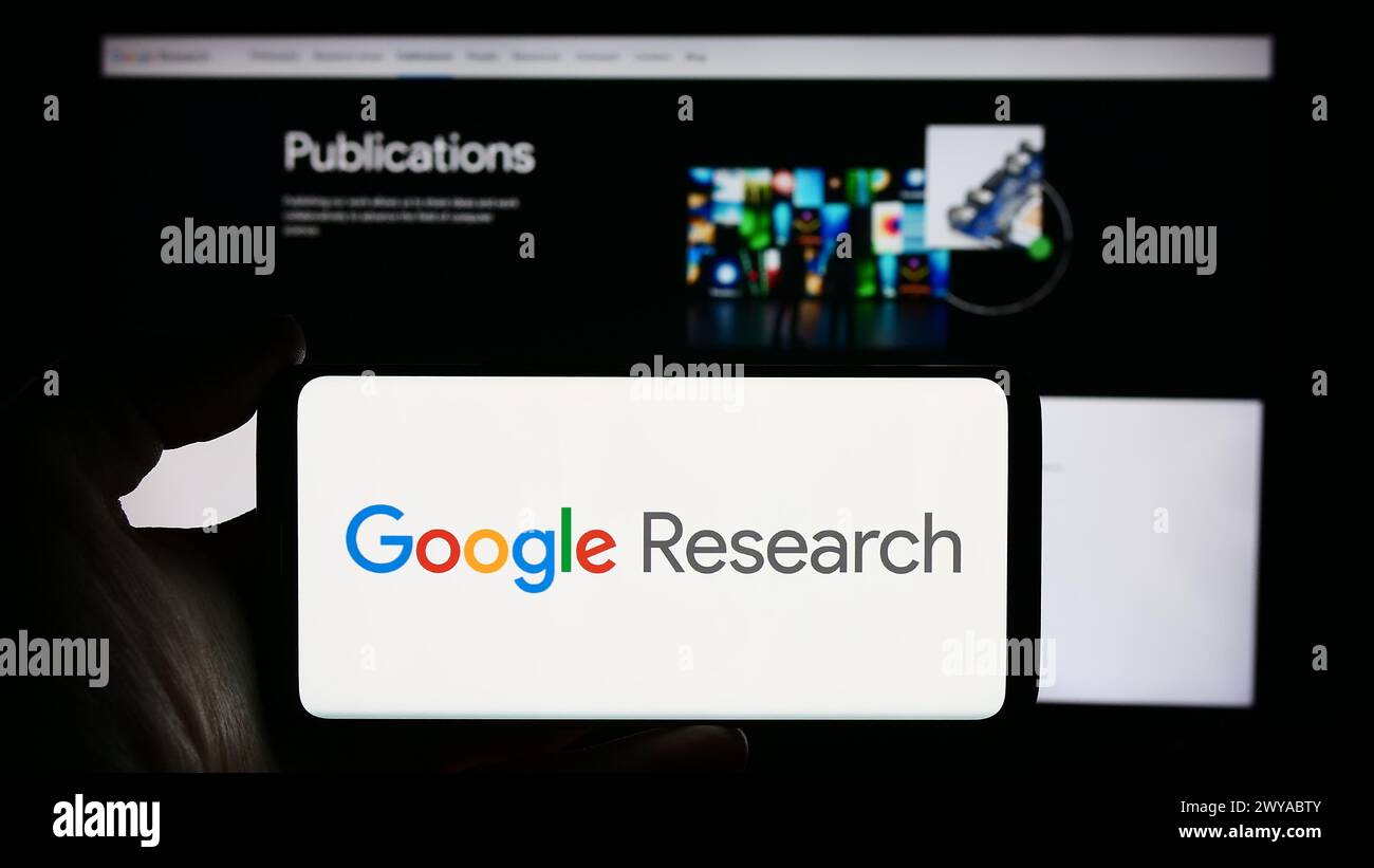 Person holding cellphone with logo of US technology company Google Research in front of business webpage. Focus on phone display. Stock Photo