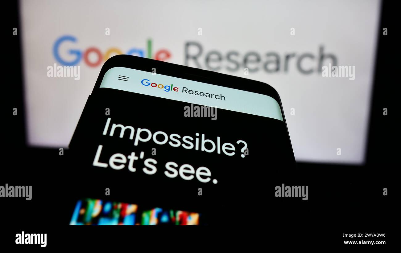 Smartphone with website of US technology company Google Research in front of business logo. Focus on top-left of phone display. Stock Photo