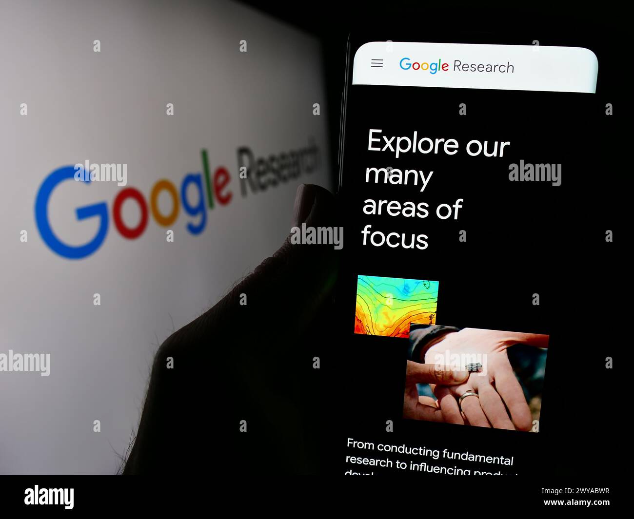 Person holding cellphone with webpage of US technology company Google Research in front of business logo. Focus on center of phone display. Stock Photo