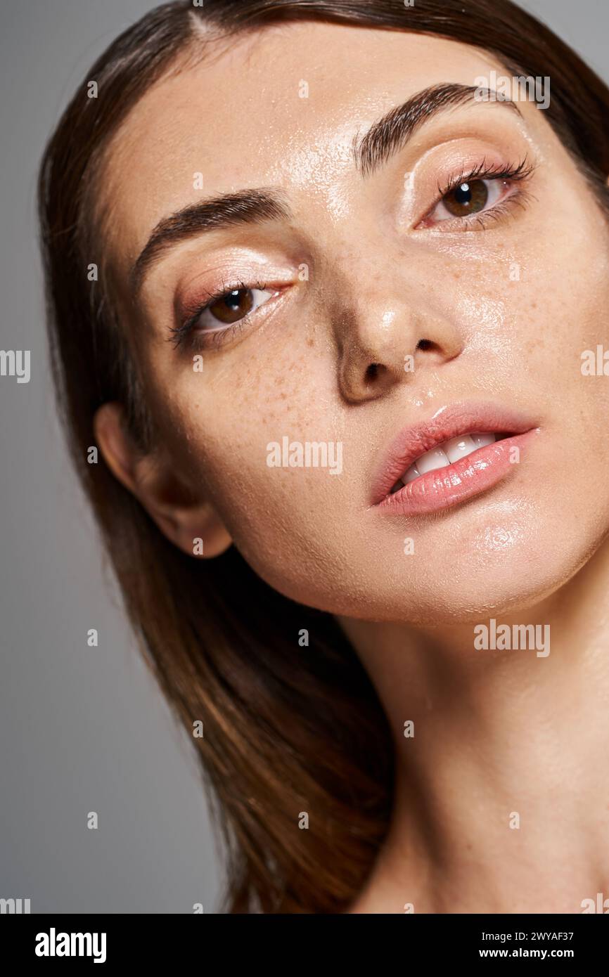 Close-up of a young caucasian woman with freckles on her face in a studio setting, showcasing her natural beauty. Stock Photo