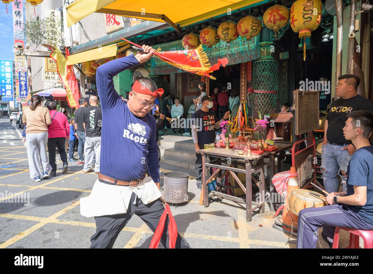 Taoist spirit medium participating in a religious ceremony with a sword and horn in front of Dongyue Temple Stock Photo
