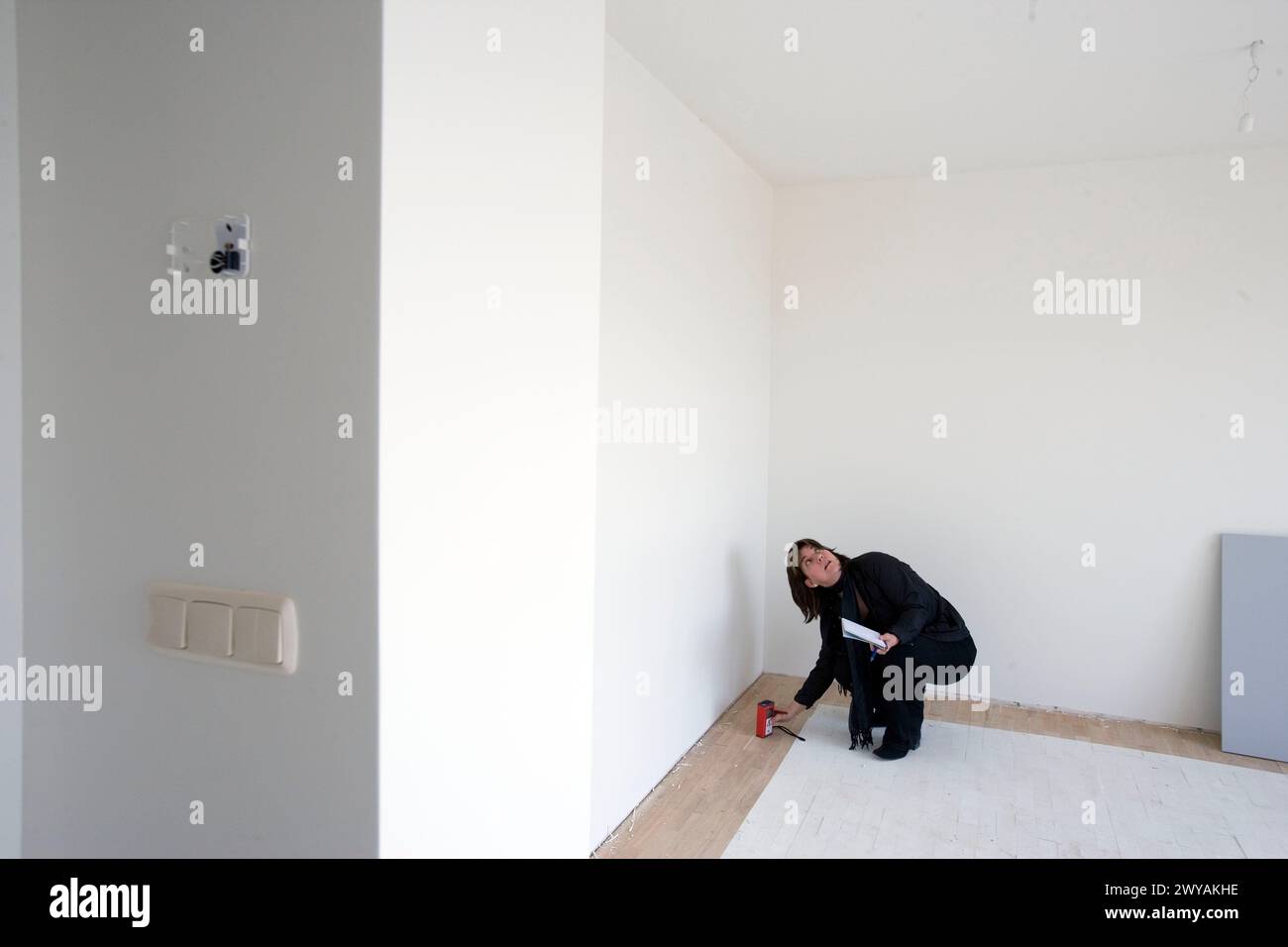 Interior decorator taking measures in empty room. Stock Photo