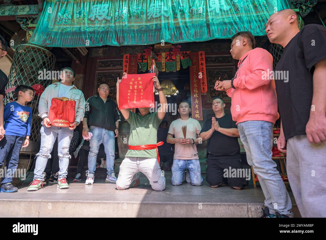 Temple ritual with individuals holding a red ritual banner Stock Photo