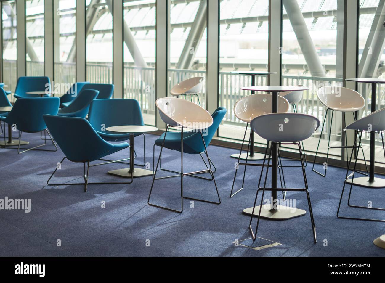 Modern chairs and armchairs in an ultra-modern hall with glass walls Stock Photo