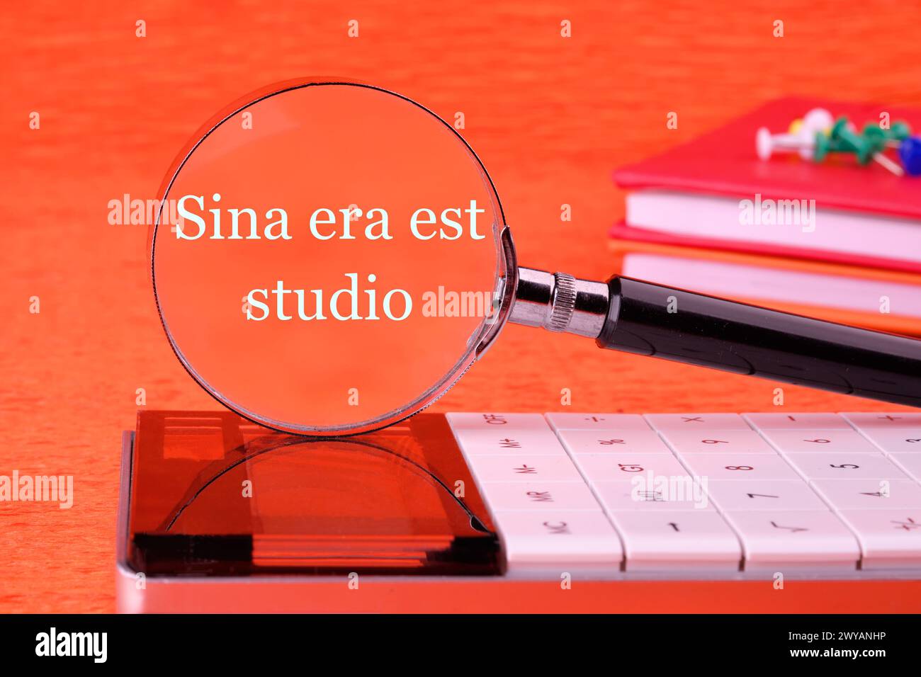 Sina era est studio It means Without anger and addiction through a magnifying glass in white font on an orange background Stock Photo