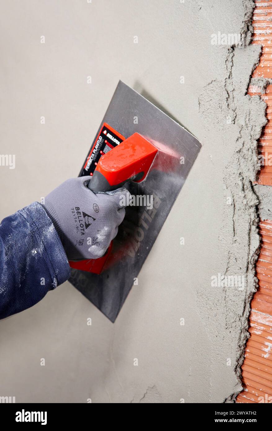 Rendering a brick wall using trowel, new homes under construction, construction site. Stock Photo