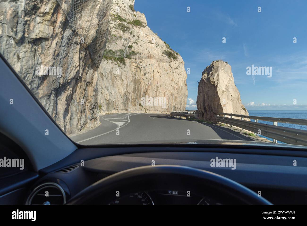 Seen from inside the car the stunning high altitude cliffside road along the coastline of Liguria, Italy Stock Photo