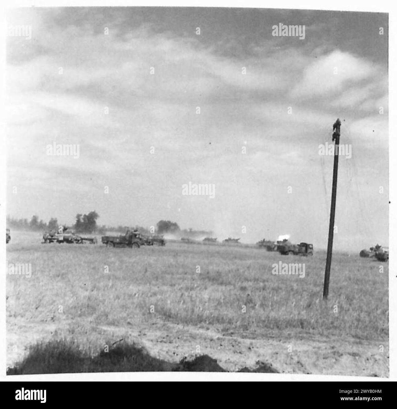 NORMANDY - VARIOUS - Original wartime caption: Mobile 25 pdr. guns firing on Falaise from a cornfield overlooking the approaches to the town. In the background our armour moves up in clouds of dust. Photographic negative , British Army, 21st Army Group Stock Photo