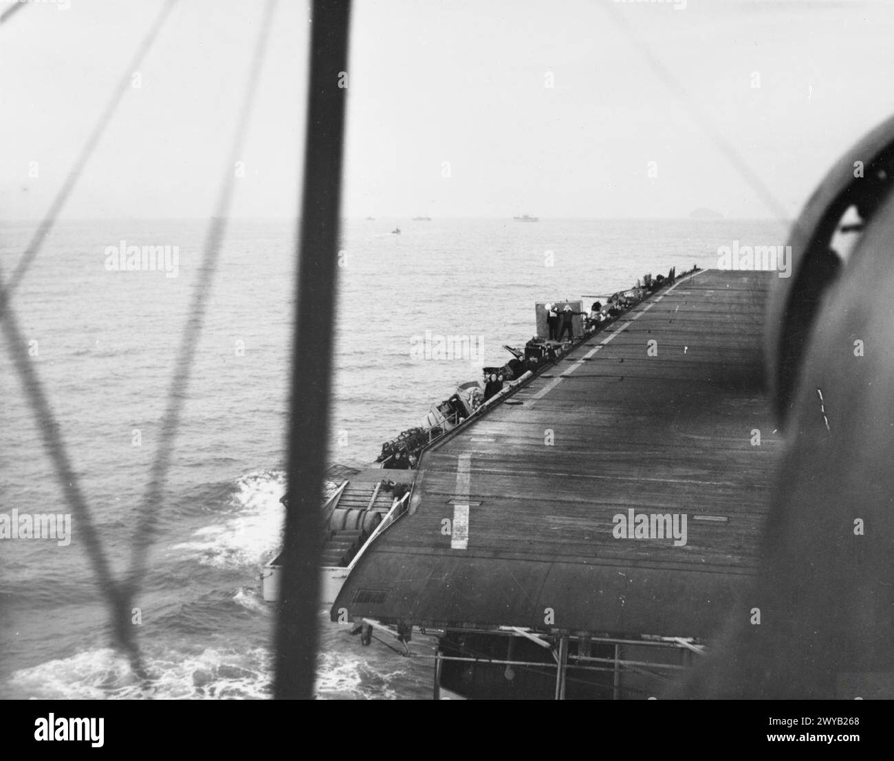 WITH THE ESCORT CARRIER HMS SMITER. 1944, AT SEA, ON BOARD A FAIREY SWORDFISH OF THE CARRIER DURING THE TRAINING OF DECK LANDING CONTROL OFFICERS, WHEN AIRCRAFT WERE TAKING OFF AND LANDING ON. - Looking down on the SMITER as a Fairey Swordfish came in to land-on. , Stock Photo
