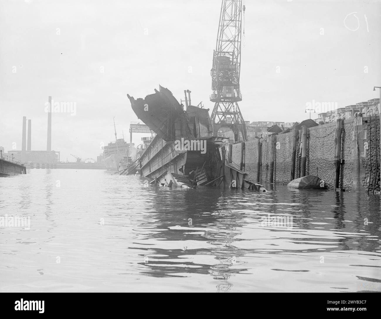 WRECKAGE IN THE BOMB-SCARRED HAMBURG DOCKS. 8 JULY 1945, WRECKED AND BURNT OUT GERMAN SHIPPING IN THE BOMB-BATTERED DOCKS AT HAMBURG. - The ROBERT LEY, 'strength through joy' ship, viewed through a bombed, torn and sunk floating dock. , Stock Photo