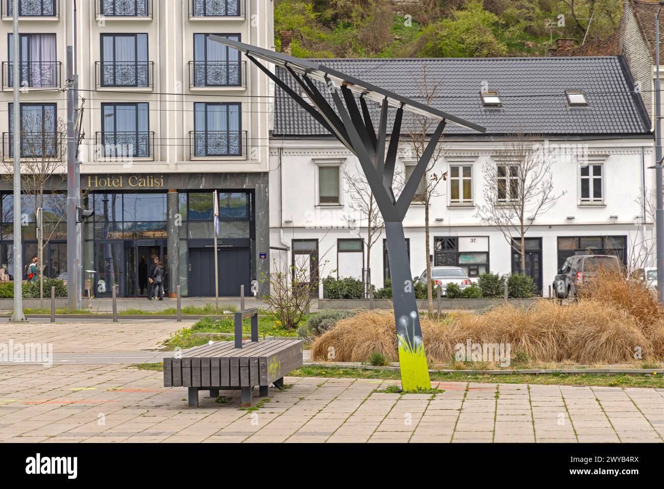 Belgrade, Serbia - March 11, 2024: Modern Solar Charger Tree and Wooden Bench With Electricity Power at Park in Downtown. Stock Photo