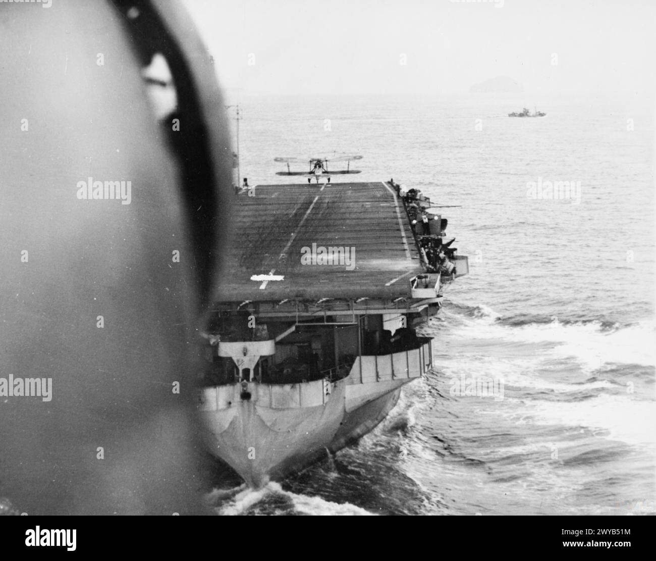 WITH THE ESCORT CARRIER HMS SMITER. 1944, AT SEA, ON BOARD A FAIREY SWORDFISH OF THE CARRIER DURING THE TRAINING OF DECK LANDING CONTROL OFFICERS, WHEN AIRCRAFT WERE TAKING OFF AND LANDING ON. - Looking down on the SMITER as a Fairey Swordfish came in to land-on. , Stock Photo