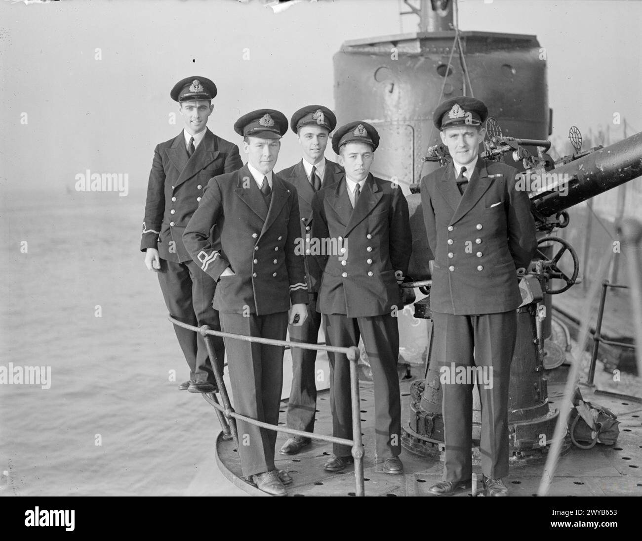 HMS SUBMARINE SHAKESPEARE, OF SICILY LANDING FAME, BACK HOME. 5 JANUARY 1943, DEVONPORT. THE SUBMARINE RETURNS AFTER 19 MONTHS OPERATIONAL ACTIVITY IN THE MEDITERRANEAN. - Officers of the SHAKESPEARE. Left to right: Sub Lieut R G Pearson, RNVR, of Hitchin, Herts (Torpedo Officer); Lieut W E Little-John, DSC, RANVR, of Melbourne, Australia (First Lieutenant); Lieut N D Campbell, RN,, of Sevenoaks (Gunnery Officer); Lieut L H Richardson, RN, of Jersey, Channel Islands (Navigating Officer); and Lieut M F R Ainslie, DSO, DSC, RN, of Ash Vale, Surrey (Commanding Officer). , Stock Photo
