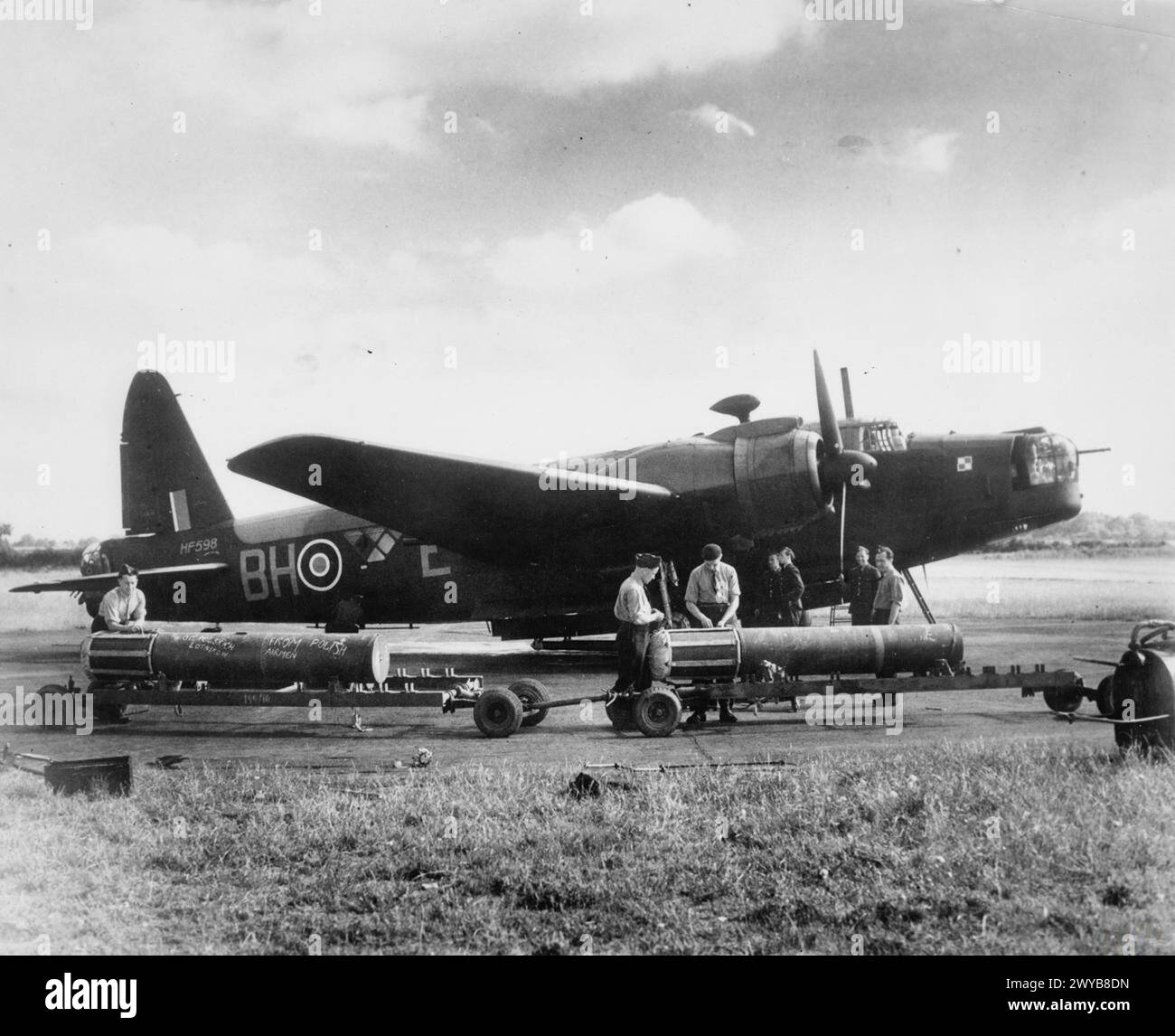 THE POLISH AIR FORCE IN BRITAIN, 1940-1947 - Final adjustments are being made to the cargo of mines before they are loaded into a waiting Vickers Wellington bomber of No. 300 Polish Bomber Squadron (BH-E, HF598) at RAF Faldingworth. The message on the mine reads 'From Polish Airmen' both in Polish and English. , Polish Air Force, Polish Air Force, 300 'Land of Masovia' Bomber Squadron Stock Photo