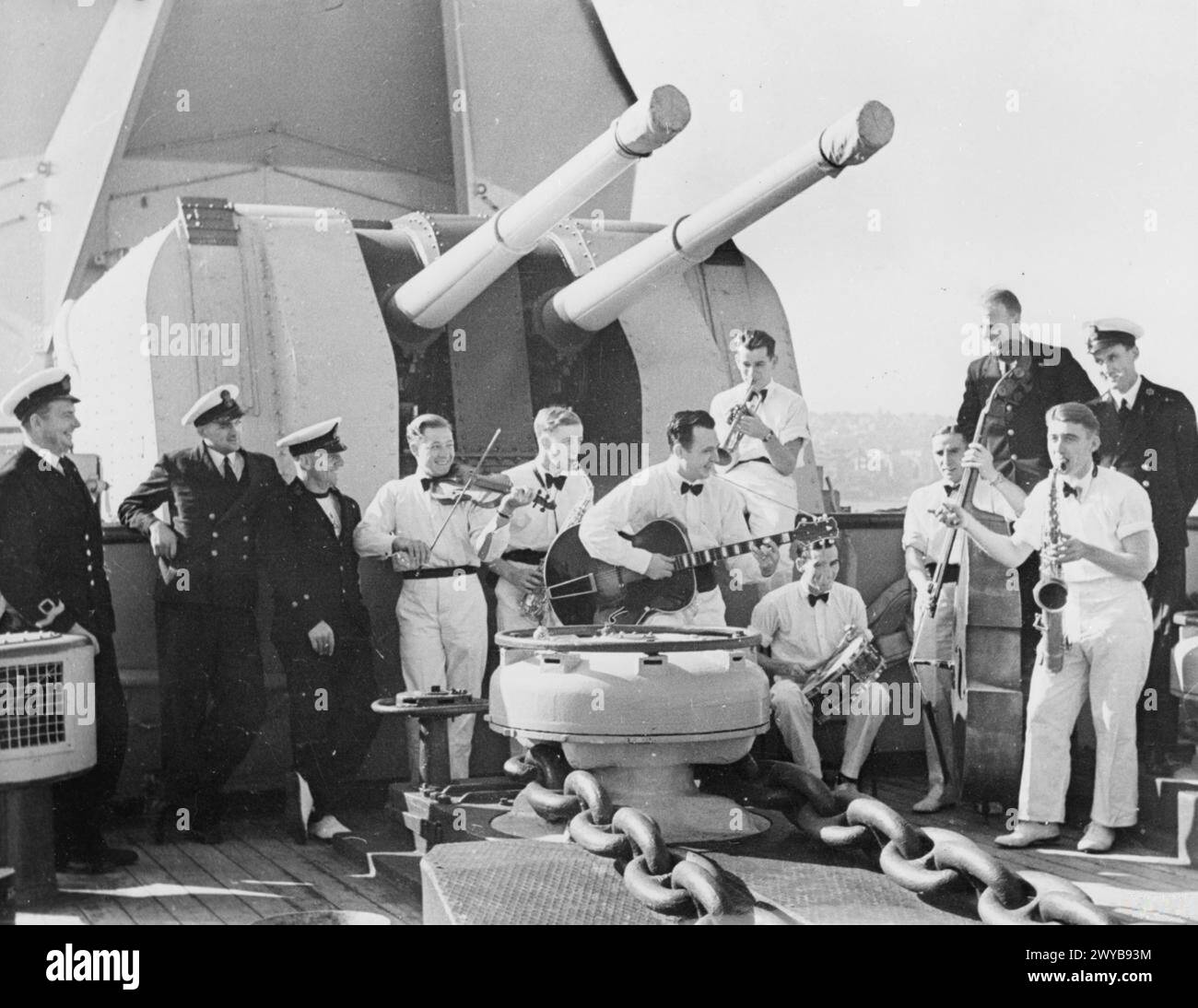 SERVING AGAINST THE JAPANESE. AUGUST 1945, PICTURES AND CARICATURES OF MEN ON BOARD THE SHIPS IN WHICH THEY SERVE IN THE FAR EAST. - Lymington Naval officer entertains Pacific Fleet. Left to right: Lieut (S) H W F Johnson, DSC, RNVR, Lymington, Hants, and Liverpool; Stoker P O K Imes, Portsmouth; Chief PTI M Watson, Portsmouth; Shipwright S Payne, Glasgow; ERA I S Finch, Maidstone; EMF Bedell, Shrewsbury; Sig C Cross, Grimsby; Leading Officers' Cook W Warwick; Leading Seaman J Church, London; Leading Supply Assistant J McKenzie, Glasgow; AB D Dougherty, Newcastle with saxophone; CE A A Riley, Stock Photo