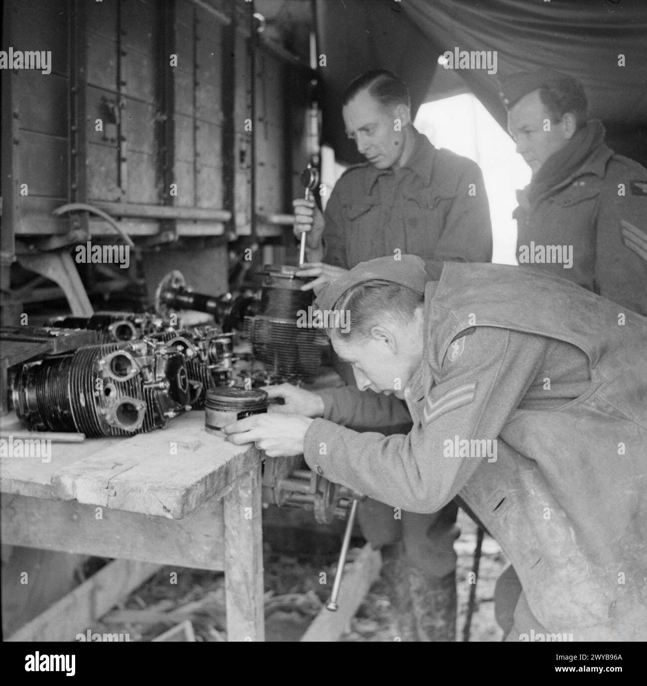 ROYAL AIR FORCE: ITALY, THE BALKANS AND SOUTH EAST EUROPE, 1942-1945. - Fitters strip down the engine of a Taylorcraft Auster Mark IV of No. 654 (AOP) Squadron RAF for repair at their mobile workshops at Forli, Italy. Checking a cylinder-head in the foreground is Corporal G Oakley of Blackheath, Birmingham, while behind him are Leading Aircraftmen W Jenkinson of Shelley, Huddersfield, and Sergeant D R Bourne of Sonning, Berkshire. , Royal Air Force, Royal Air Force Regiment, Sqdn, 188 Stock Photo