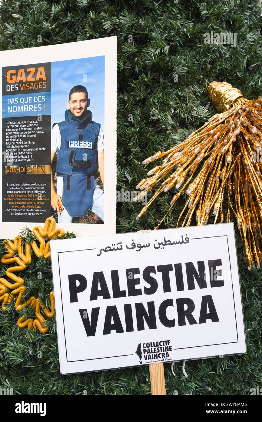 On the gold-colored Christmas tree in Place Arnaud Bernard, posters of Palestine will prevail, and another with Gaza faces, Not all numbers ! Stock Photo