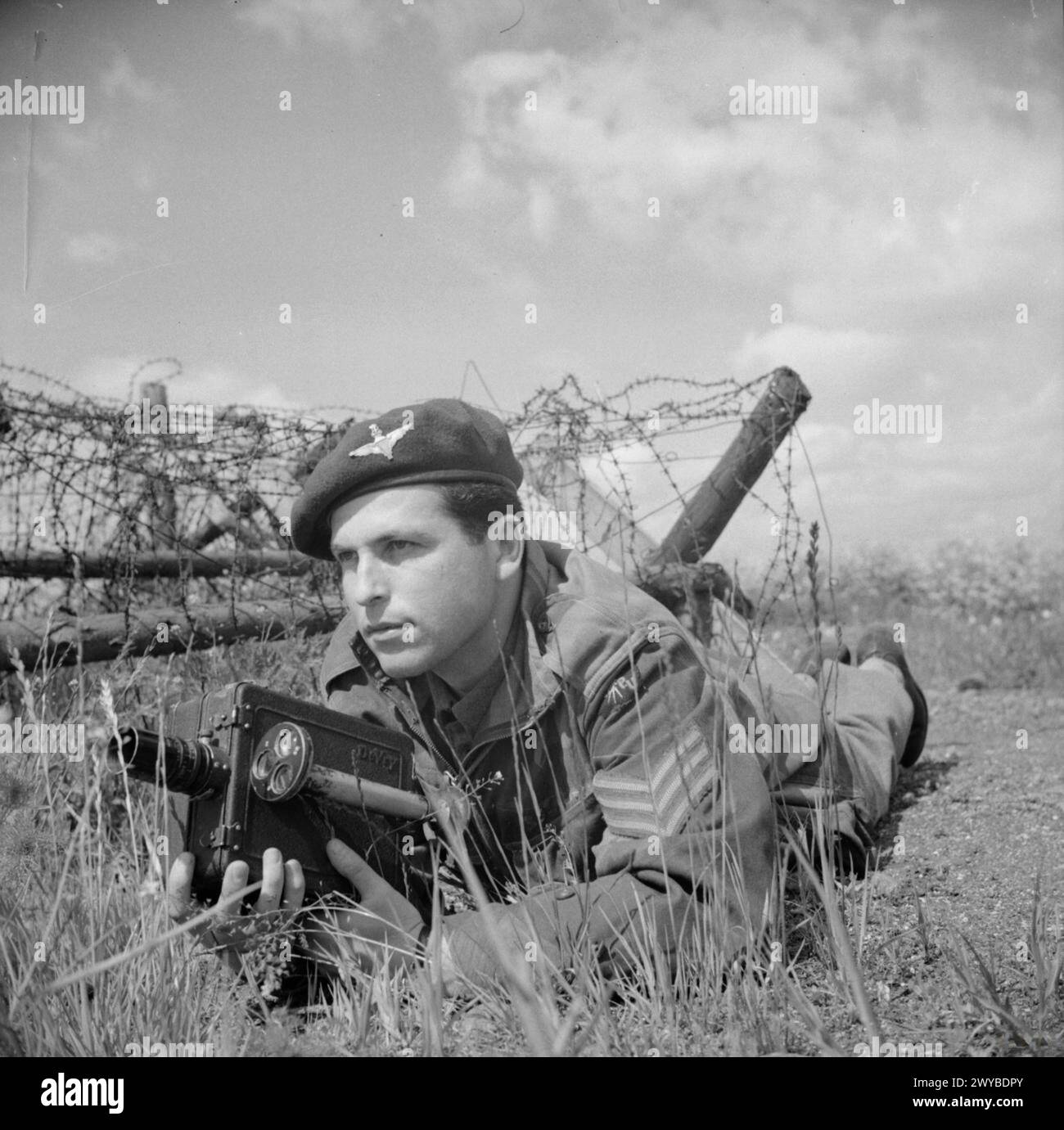 Sergeant Mike Lewis of the Army Film Unit poses with a De Vry camera ...