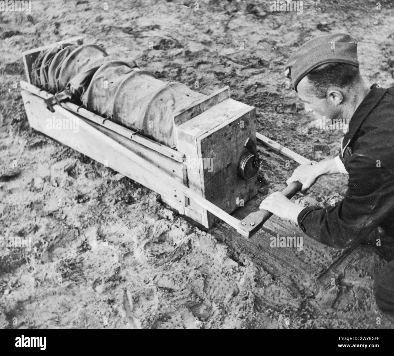 THE GREAT ESCAPE, MARCH 1944 - Corporal Karl Greise, one of the German guards known as 'Rubberneck', demonstrating a device used for pumping air into the 'Harry' escape tunnel at Stalag Luft III, Sagan. Photograph probably taken in late March 1944. , Royal Air Force, German Air Force, Greise, Karl Stock Photo