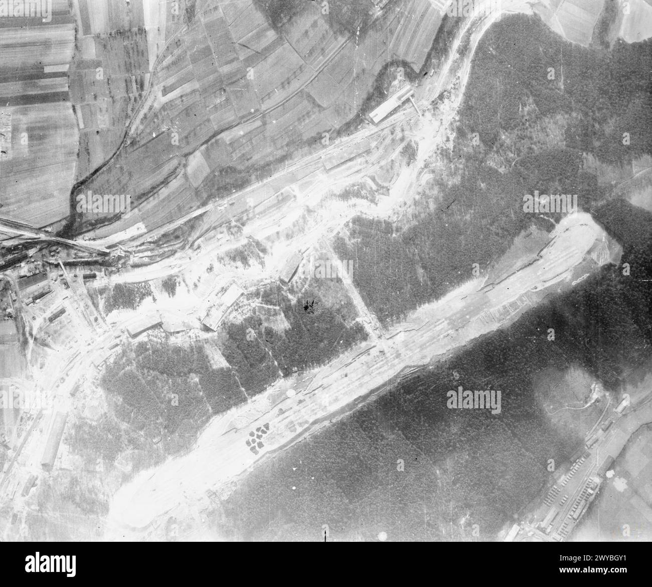 ROYAL AIR FORCE: OPERATIONS BY THE PHOTOGRAPHIC RECONNAISSANCE UNITS, 1939-1945. - Vertical aerial reconnaissance view of the airstrip running along the top of the Walpersberg (lower right), by the village of Grosseutersdorf, near Kahla, Thuringia, Germany, under which a subterranean factory for the assembly of Messerschmitt Me 262 jet fighters had been built. The facility was being built by Flugzeugwerke Reichsmarschall Hermann Göring (REIMAHG), a special state-owned company which employed foreign forced laborers and a small number of, mainly Soviet, prisoners of war, as well as specialist Ge Stock Photo