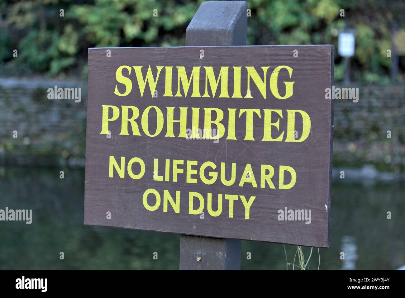 swimming prohibited no lifeguard on duty sign at famous swimming hole (waterfall in ithaca) safety, life guard, drowning threat, water sport, swim, su Stock Photo