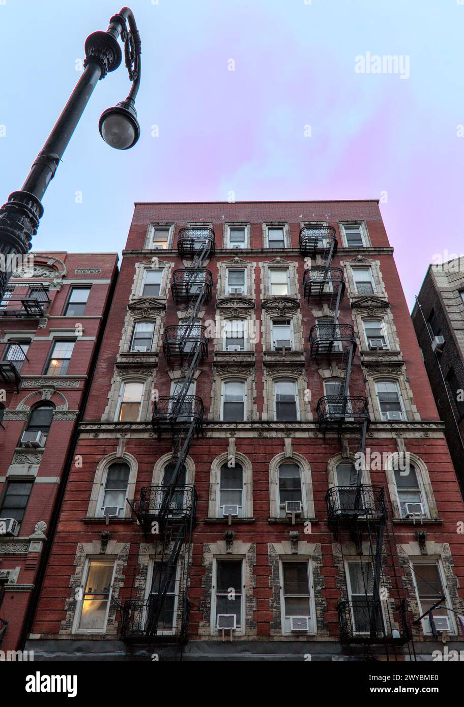 typical lower east side apartment building (tenement with fire escape, windows, lamp post) detail (red brick) Stock Photo