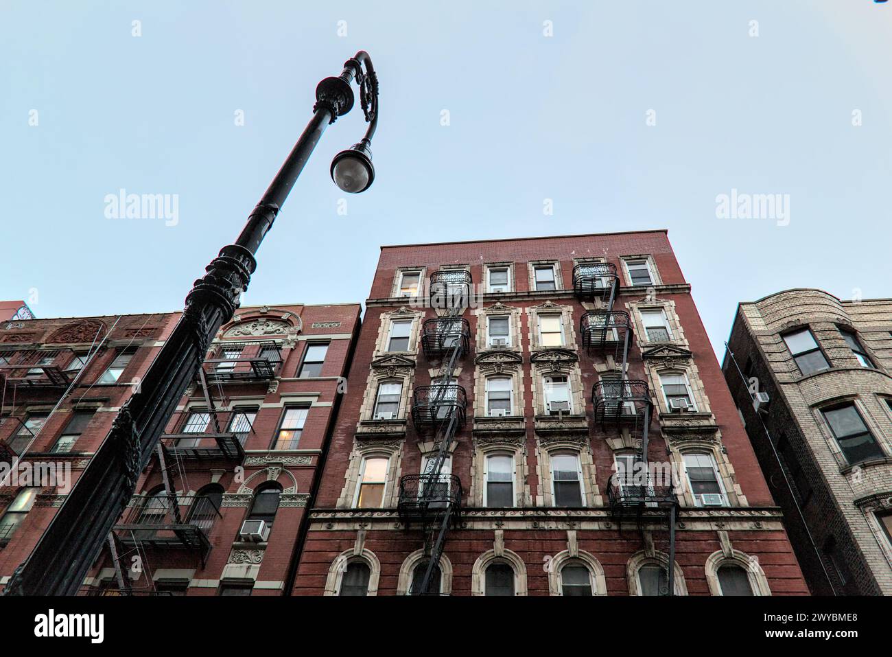 typical lower east side apartment building (tenement with fire escape, windows, lamp post) detail (red brick) Stock Photo