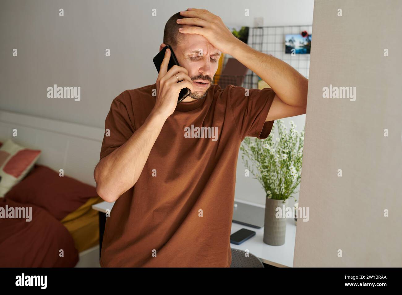 Mature man suffering from severe headache calling his doctor Stock Photo