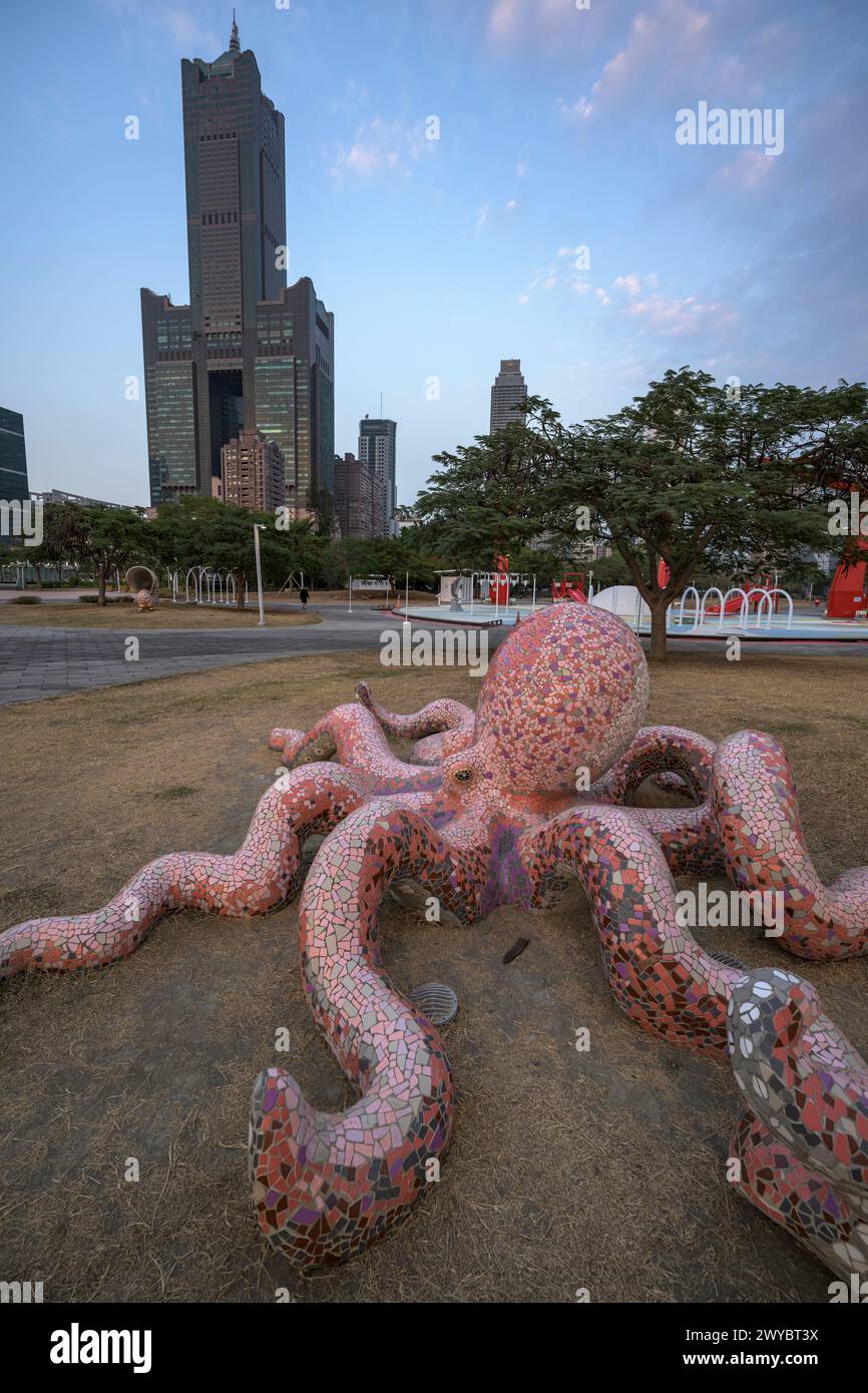 An intricate giant octopus sculpture sprawls across the ground with a modern cityscape rising behind Stock Photo
