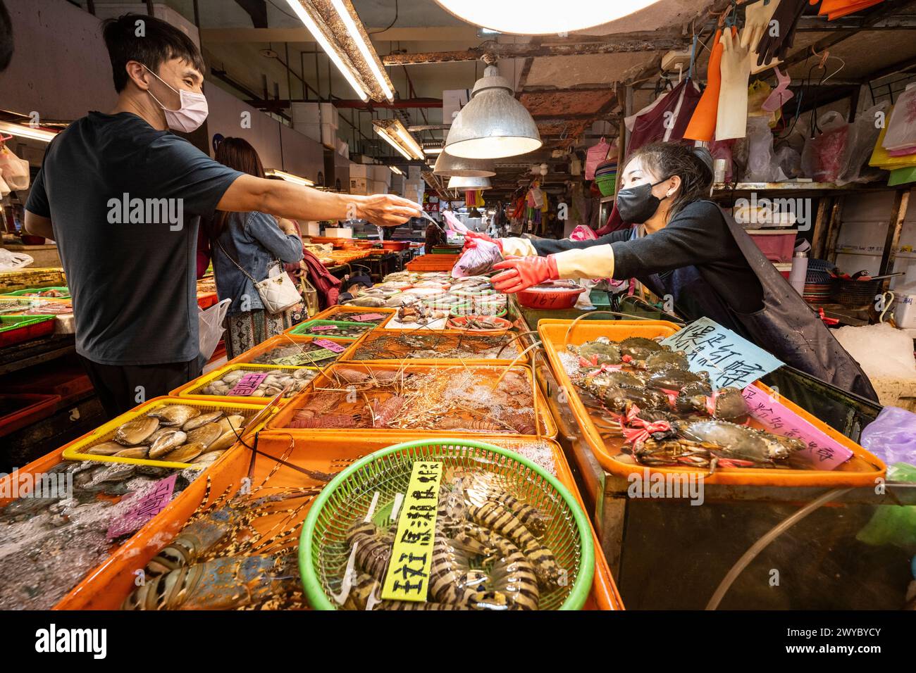 A transaction unfolds as fresh seafood is exchanged at a lively market Stock Photo