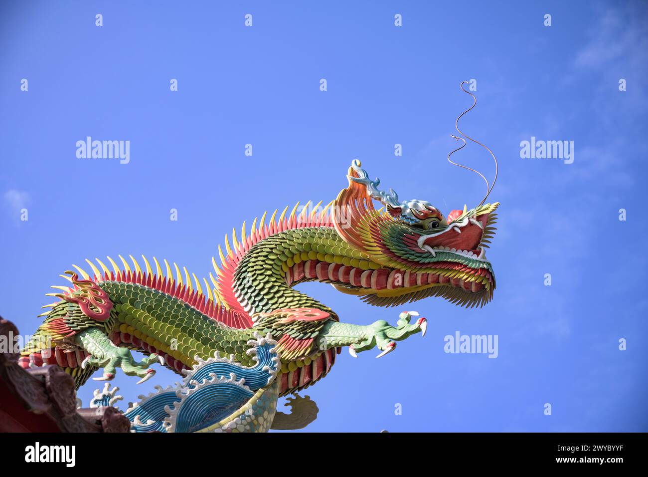Colorful and intricate dragon sculptures adorning the roof of a traditional Taiwanese temple against a clear sky Stock Photo
