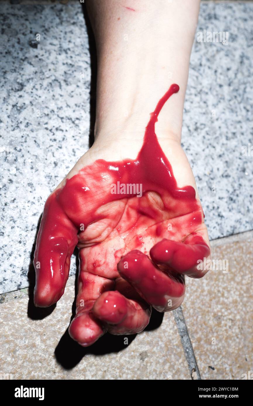DIE-IN. A blood-red hand on the ground. Mobilization organized by NousToutes82 for the World Day of the right to abortion, the right to voluntary. Stock Photo