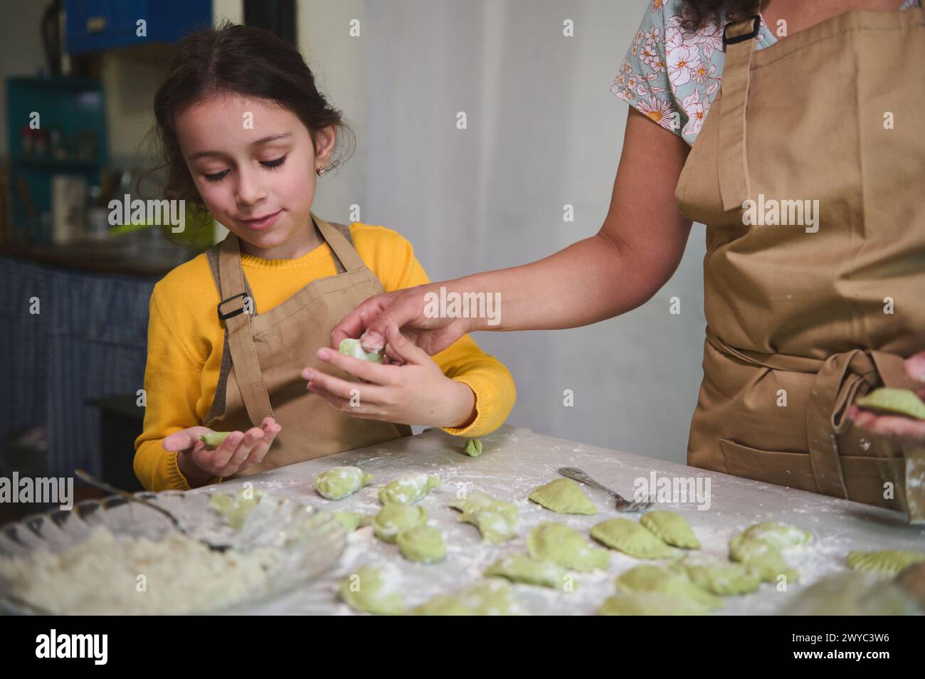 Mom and daughter cooking dumplings together in the home kitchen Stock Photo