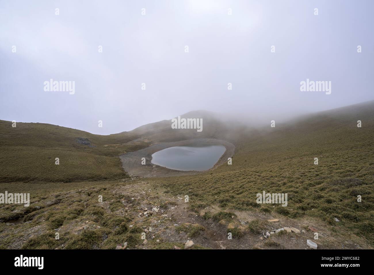 A serene Jiaming Lake nestled in mountains, shrouded in mist in wintertime Stock Photo