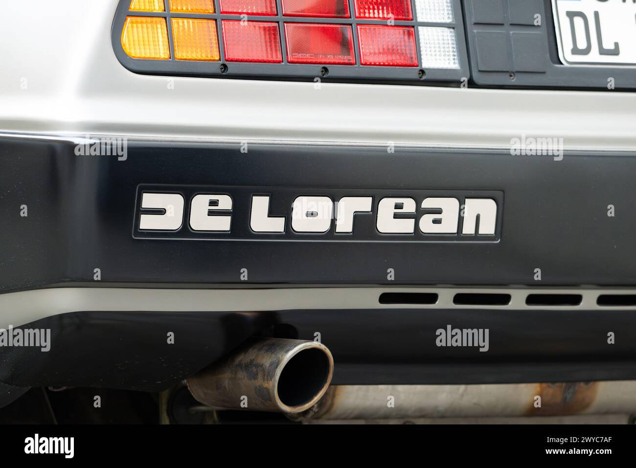 DeLorean logo sign close up of the legendary classic car exterior. Emblem on the rear bumper body part over the exhaust pipe. Stock Photo