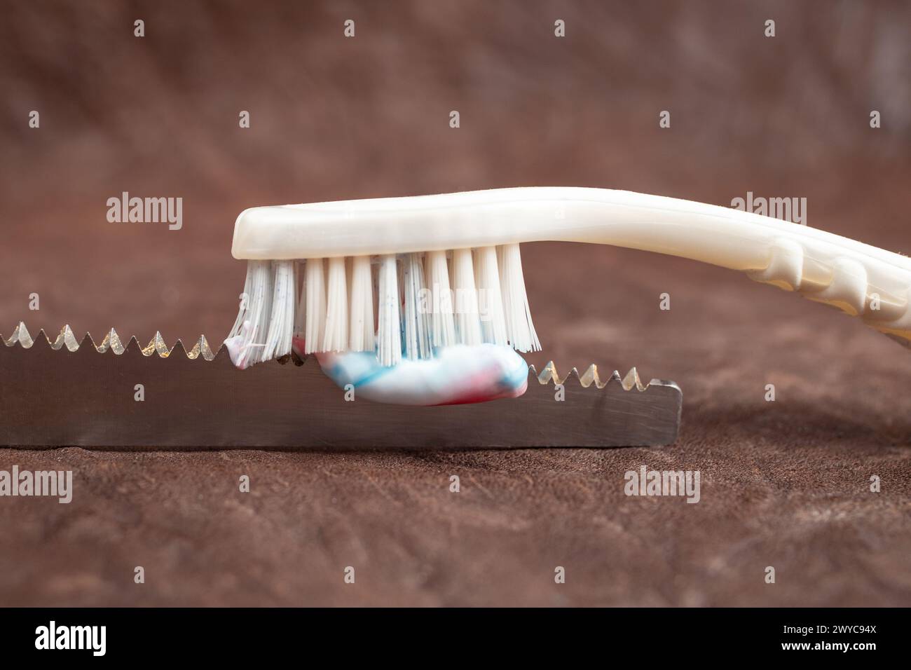 Tooth brush and paste on a saw, on leather background , soft focus ...